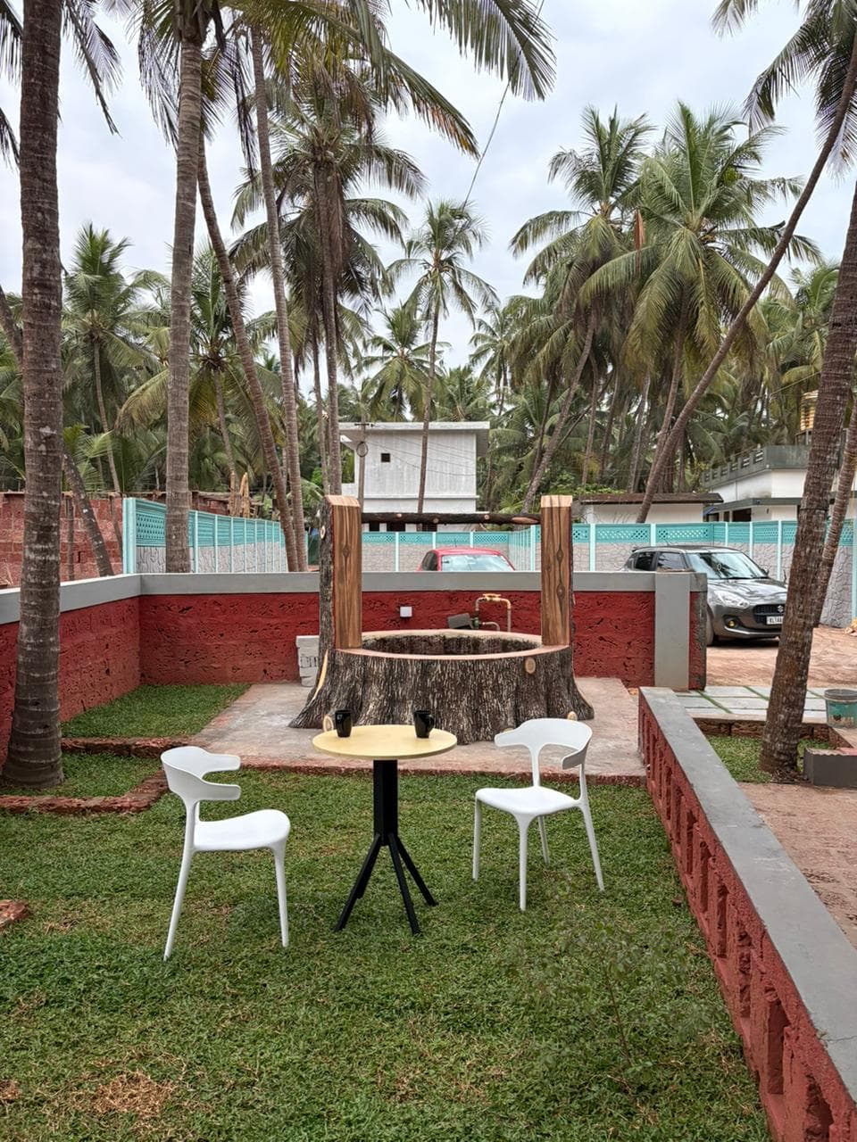 Garden lawn with cafe armchairs and rustic well