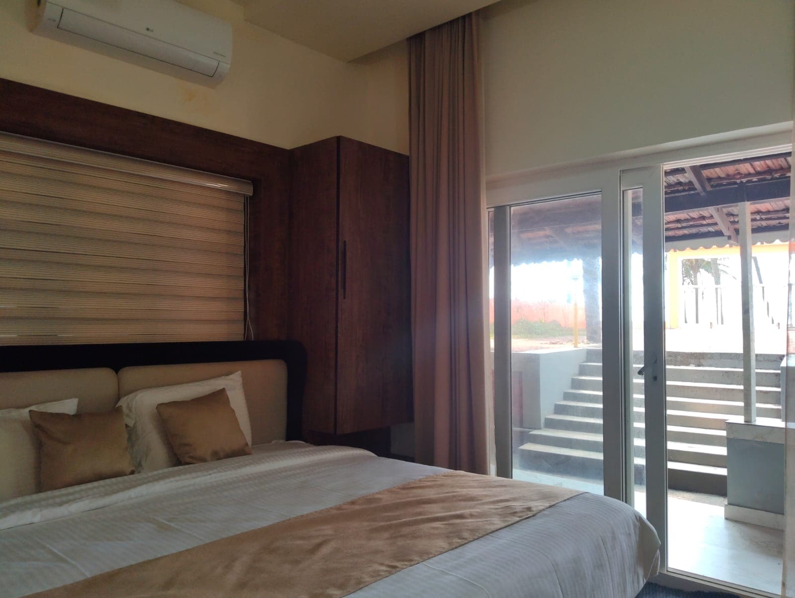 Lower Ground Bedroom One with floor-to-ceiling glass sliding doors opening to patio and garden steps