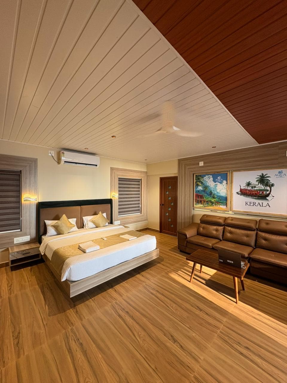 Upper Grand Suite with plush leather recliner sectional sofa and warm slatted wood ceiling